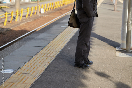 朝の通勤電車と駅で電車待ちの男性乗客の姿