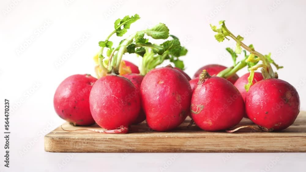 Fresh red radish bundle on chopping board on table Fresh red radish bundle on chopping board on table