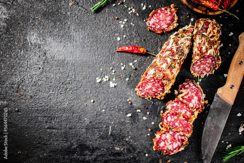 Pieces of salami sausage with dried chili peppers and rosemary. 