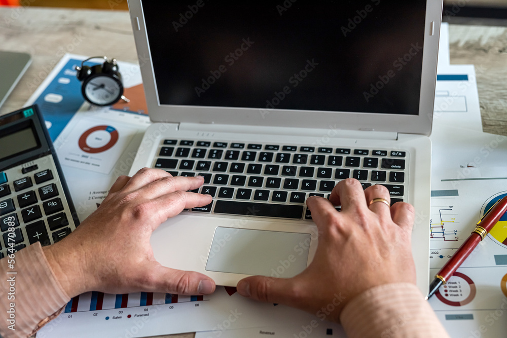Male strong hands of worker working on laptop at table. Male strong hands of worker working on laptop at table.