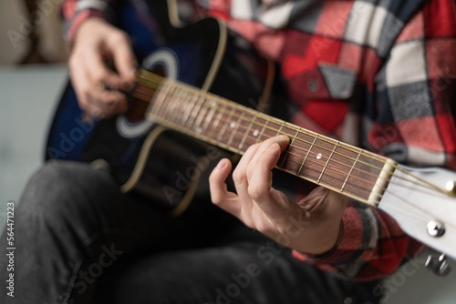 Practicing in playing guitar. Close up of male hands playing guitar.