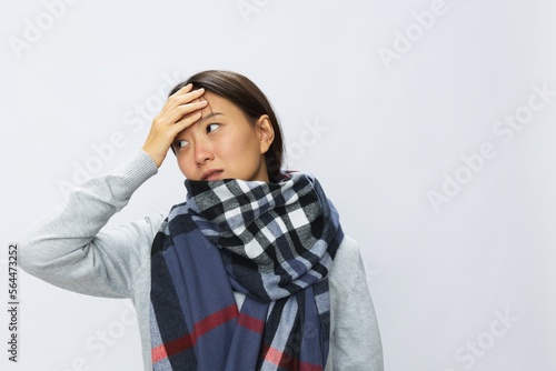 Asian woman cold flu raised hands from headache and toothache with fever sick from covid 19 virus in checkered scarf on white background, copy space