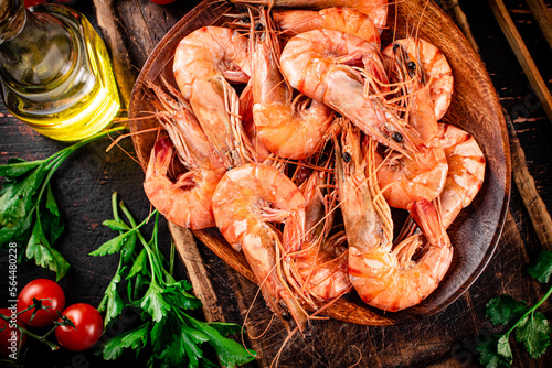 Boiled shrimp on a plate with tomatoes and parsley. 