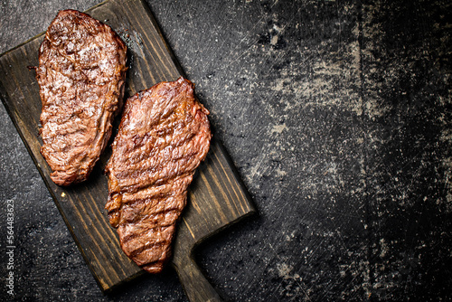 Foto Grill steak on a wooden cutting board.