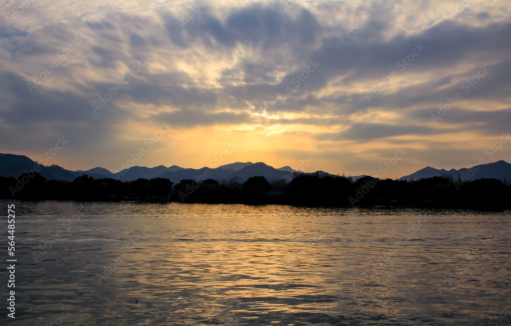 A calm seascape with mountains at sunset. Dramatic sky and cloudscape. For travel, background and blog etc. concepts. West Lake. Popular park of Hangzhou city China