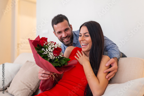 Foto Beautiful, happy, positive couple embracing, holding bouquet of red roses, 14 February happy Valentines day