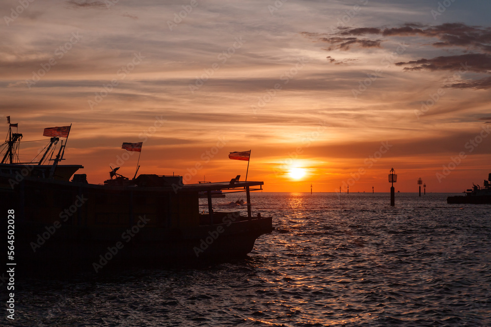 Silhouettes of fishing boats with Malaysian flags