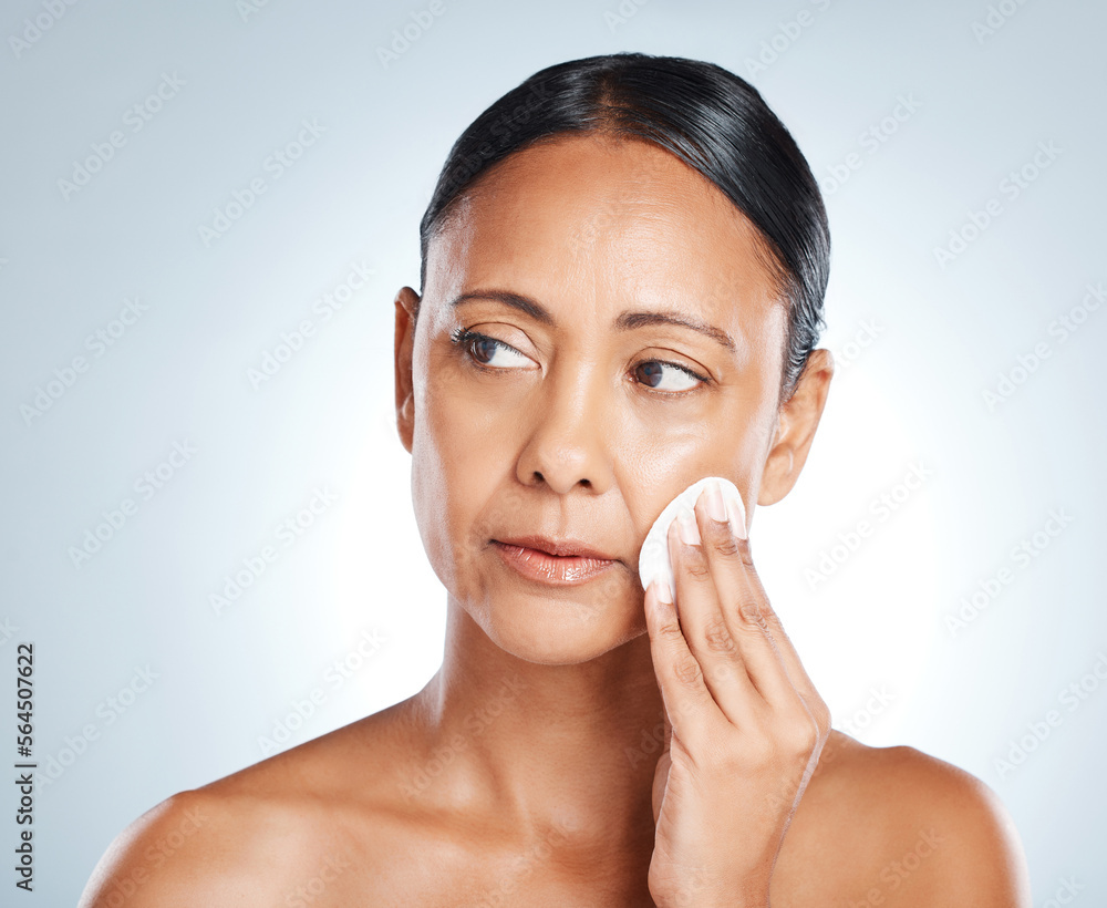Face, beauty and senior woman with cotton in studio isolated on gray background. Thinking, cosmetics product and mature female model with facial pad to remove makeup for cleaning, skincare or hygiene Face, beauty and senior woman with cotton in studio isolated on gray background. Thinking, cosmetics product and mature female model with facial pad to remove makeup for cleaning, skincare or hygiene