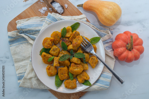 Healthy home made Pumpkin gnocchi with cheese and fresh herbs on a table