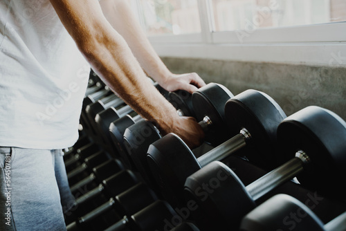 Smart sport man lifting dumbbell in fitness gym