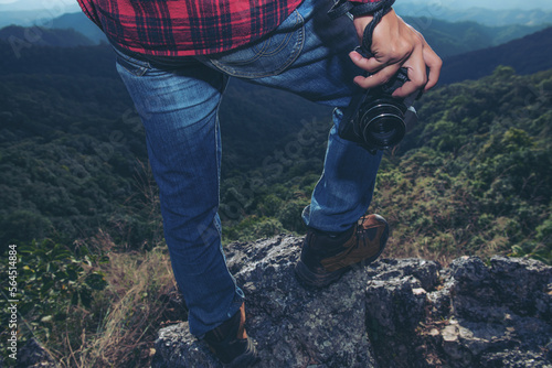 foot of young Man Traveler with backpack relaxing outdoor with rocky mountains on background Summer vacations and Lifestyle hiking concept.