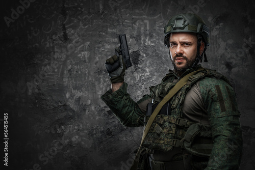 Contemporary soldier dressed in green protective uniform with rifle and handgun.