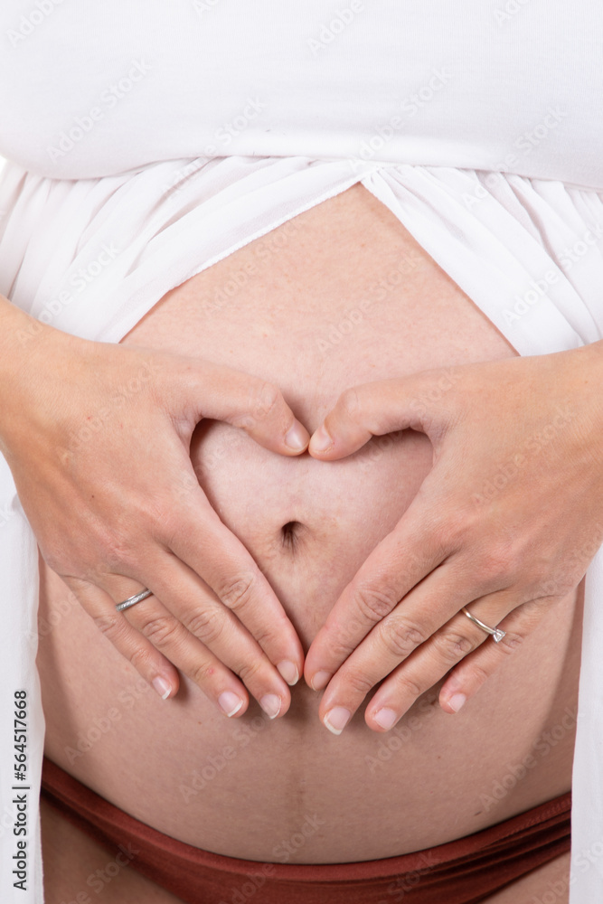 pregnant woman body topless abdomen belly with hands finger in heart sign