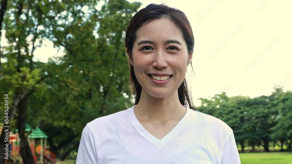 Portrait young asian woman walks gracefully in slow motion, smiles in a good mood and is in good health preparing for exercise in the garden in the morning. Portrait young asian woman walks gracefully in slow motion, smiles in a good mood and is in good health preparing for exercise in the garden in the morning.