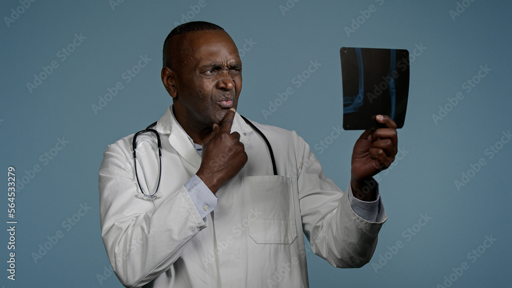 Mature serious man radiologist doctor examining x-ray check results ...