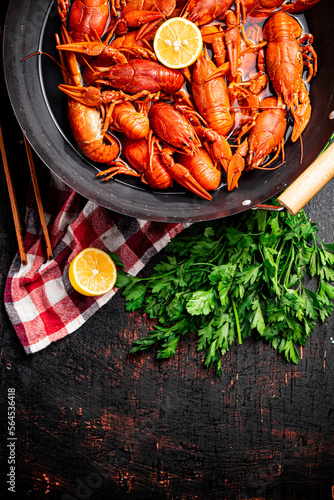 Boiled crayfish in a pot with parsley and lemon. 