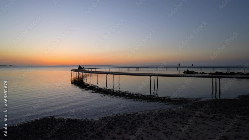 Sunset View From The Shoreline Of A Jetty By The Sea Sunset View From The Shoreline Of A Jetty By The Sea
