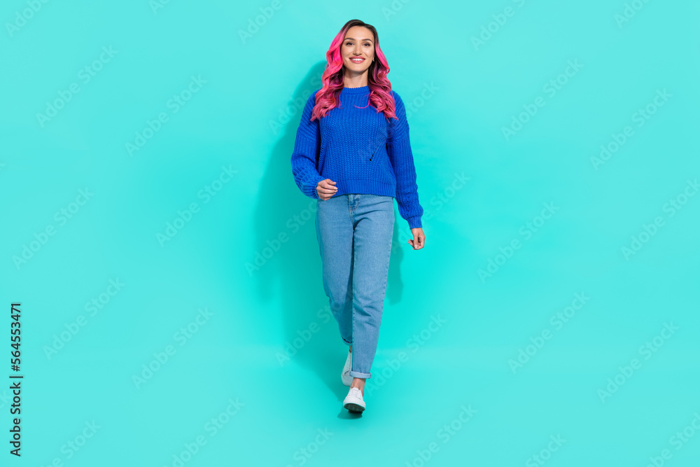 Full length size photo of successful blogger extravagant hipster lady wear blue knit jumper with denim jeans walk isolated on cyan color background Full length size photo of successful blogger extravagant hipster lady wear blue knit jumper with denim jeans walk isolated on cyan color background