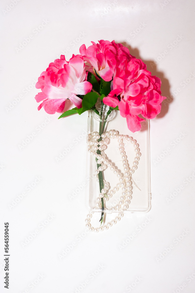Obraz premium Transparent smartphone case with flowers and beads. copy space. isolated