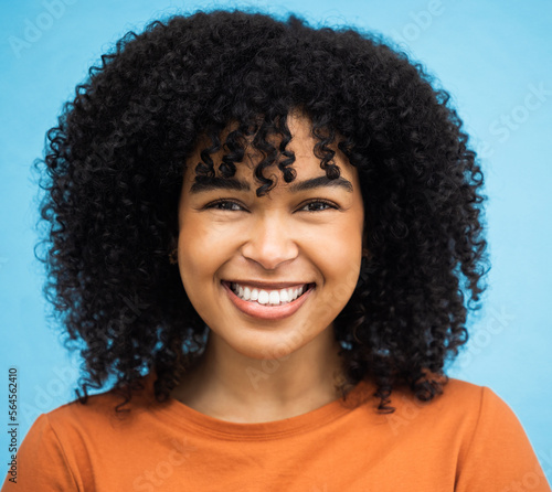 Happy, black woman or afro hairstyle portrait on isolated blue background in keratin treatment, self love or healthcare wellness. Headshot, smile or beauty model and curly brunette on urban city wall
