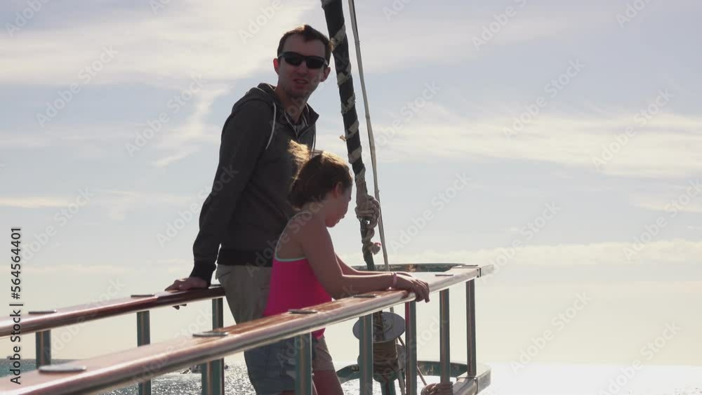 Father anf little girl in pink top and standing on the deck of the yacht Father anf little girl in pink top and standing on the deck of the yacht