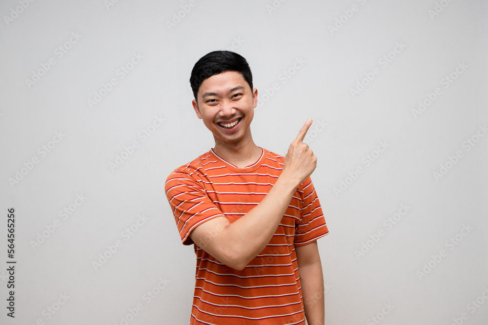 Positive asian man striped shirt happiness smile gesture point finger isolated Positive asian man striped shirt happiness smile gesture point finger isolated