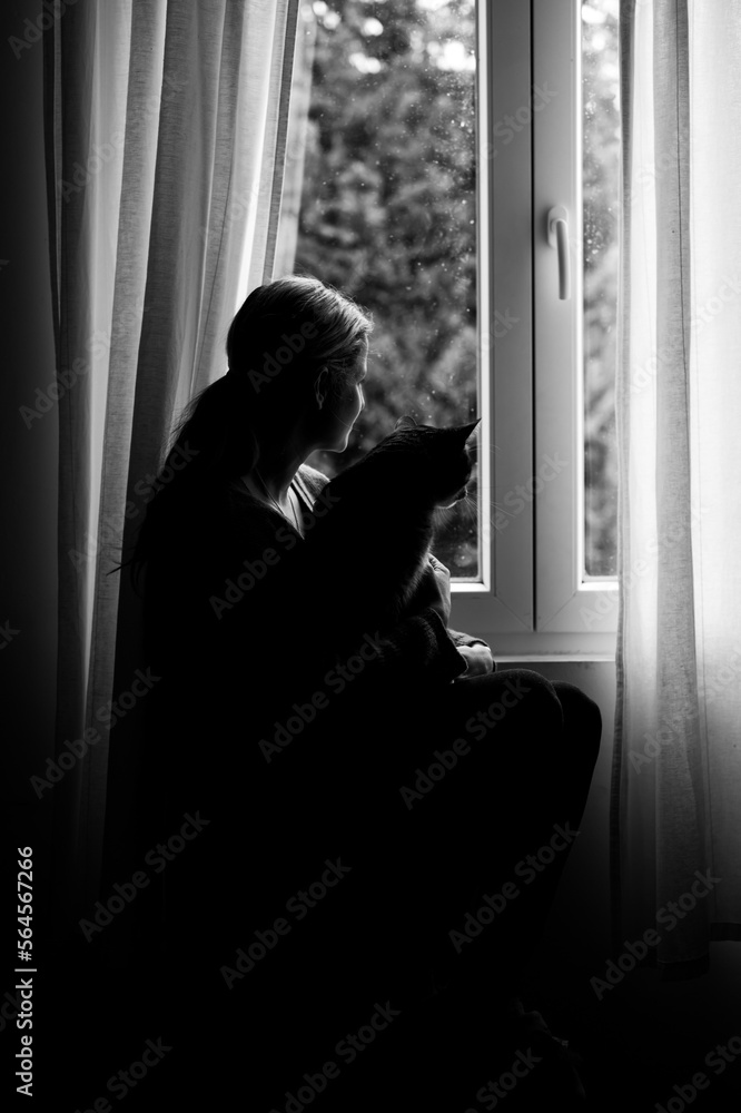 Girl sitting with cat at window silhouette - black and white photography