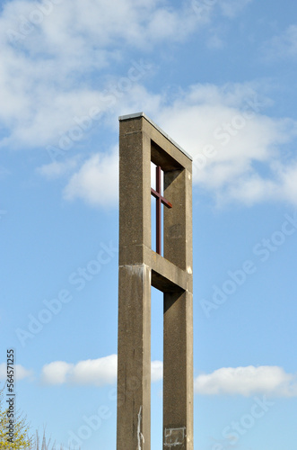Modern Concrete Tower and Cross on Church seen against Blue Sky 