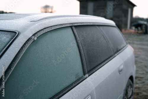 Frozen car on the outside parking. Transport in winter. Vehicle close-up with frozen windshield and windows.
