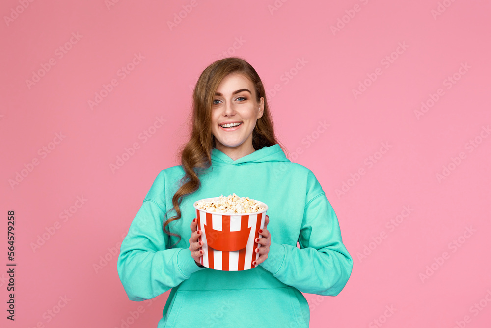 woman in sweatshirt watching movie film, eating popcorn woman in sweatshirt watching movie film, eating popcorn