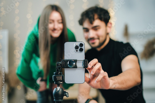 Couple using smartphone turning on music enjoying dance together performing and recording video blogging. Lifestyle bloggers creating entertainment content for