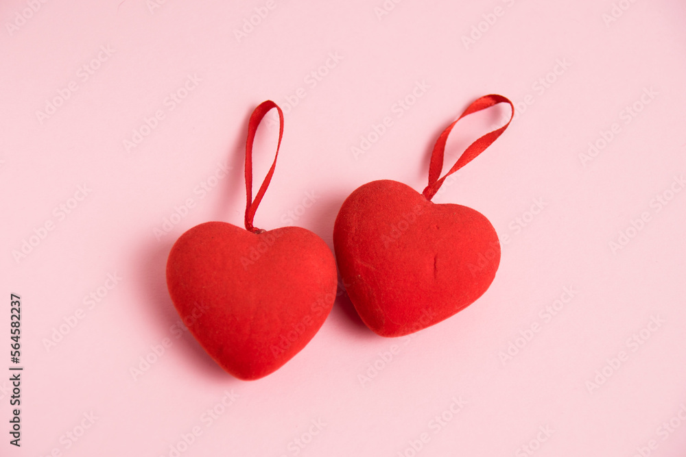 Valentine's Day celebration concept. Two red hearts on a pink paper background