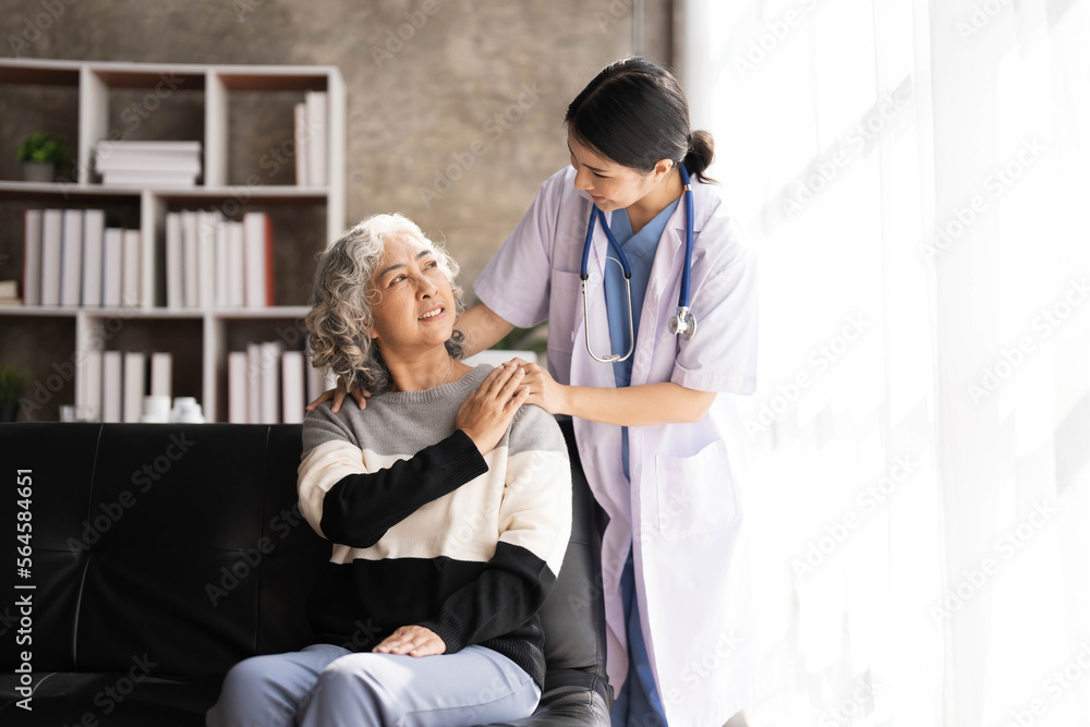 Obraz premium Young caregiver helping senior woman walking. Nurse assisting her old woman patient at nursing home. Senior woman with walking stick being helped by nurse at home.