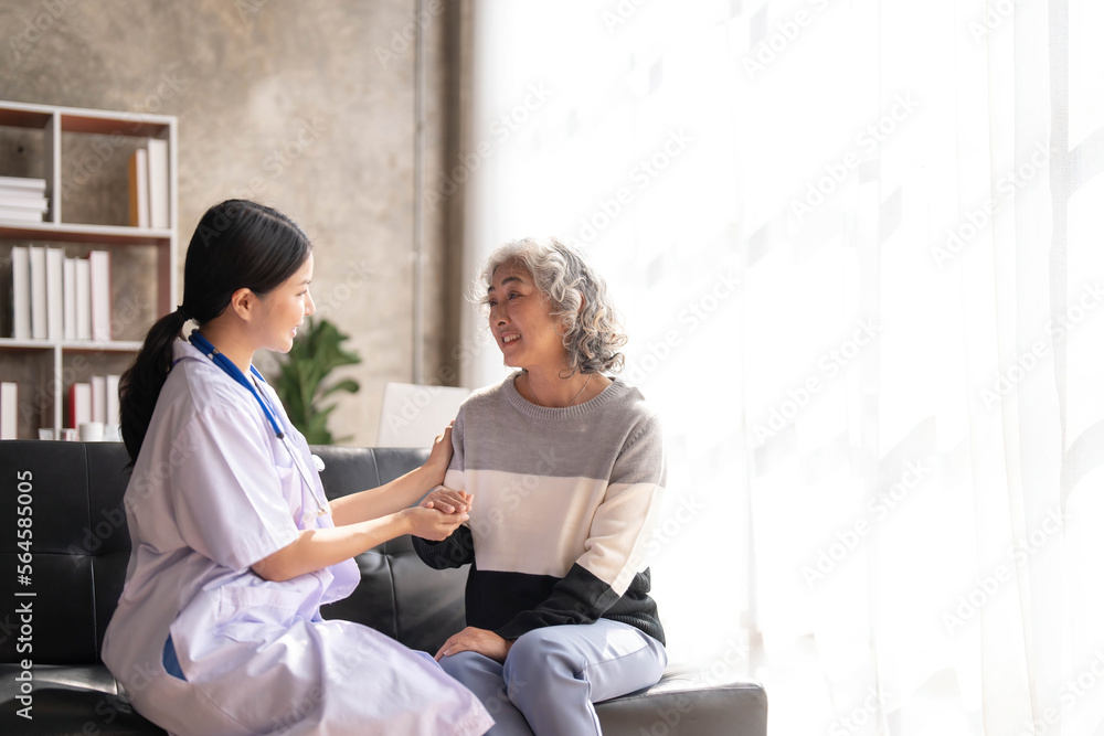 Obraz premium Young caregiver helping senior woman walking. Nurse assisting her old woman patient at nursing home. Senior woman with walking stick being helped by nurse at home.