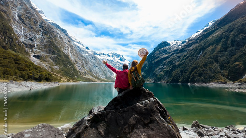  Travelers couple team look on the mountain landscape. Travel and active life concept  as Adventure travel in the mountains region in lake marian  fiordland national park