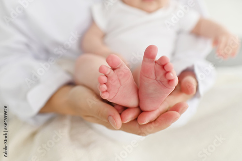 Baby feet in mother hands. Mom and her Child. Happy Family concept. Beautiful conceptual image of Maternity © Людмила Колядицкая