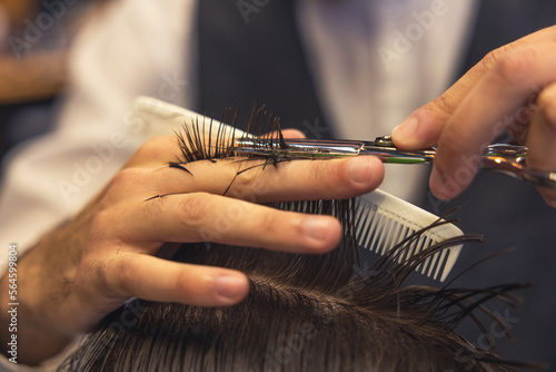 Close up of hairdressers hands cutting hair