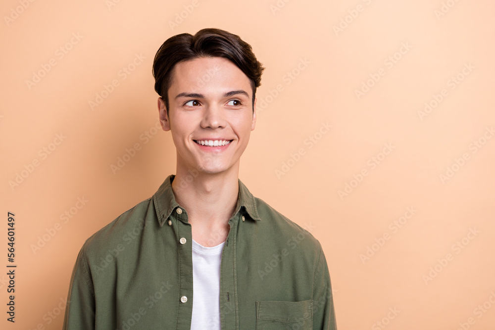 Fototapeta premium Photo of positive cheerful person beaming smile look interested empty space isolated on beige color background
