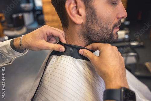 Barber covering a client with a napkin