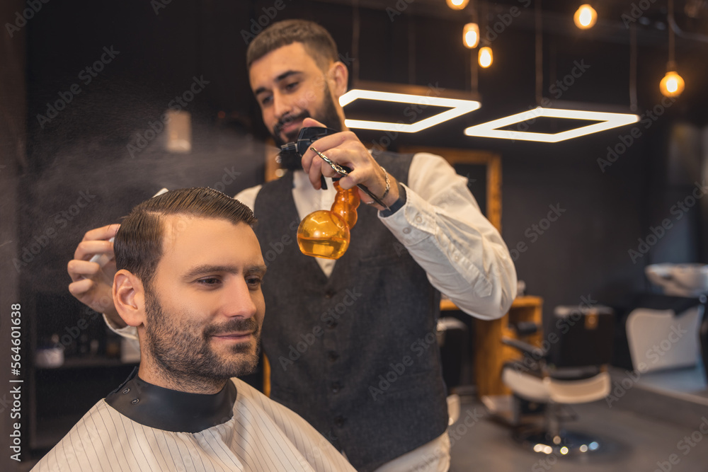 Hairdresser making a new haircut to the male client