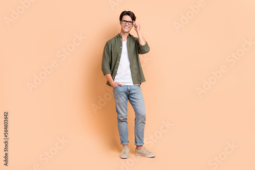 Full body length size cadre of young optimistic man wear stylish outfit casual style new eyeglasses advertisement isolated on beige color background