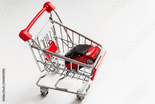 Red toy car inside small shopping cart