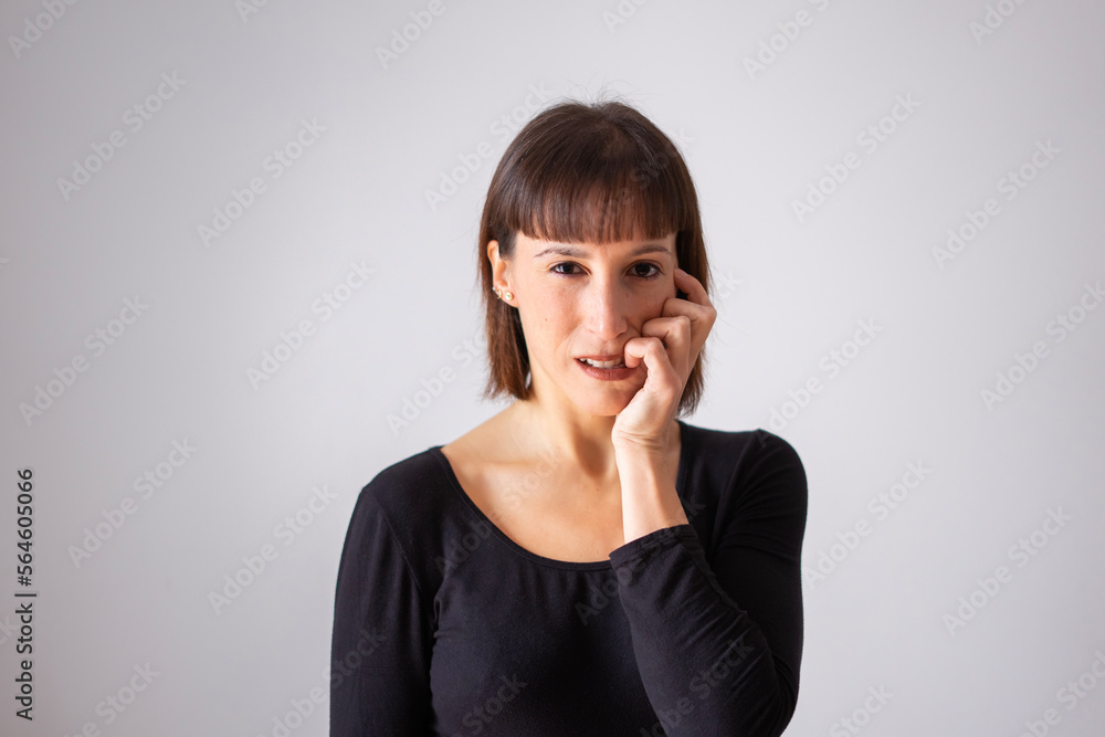 Portrait of a girl on white background. Brown short hair girl. Nervous girl biting her nails Portrait of a girl on white background. Brown short hair girl. Nervous girl biting her nails
