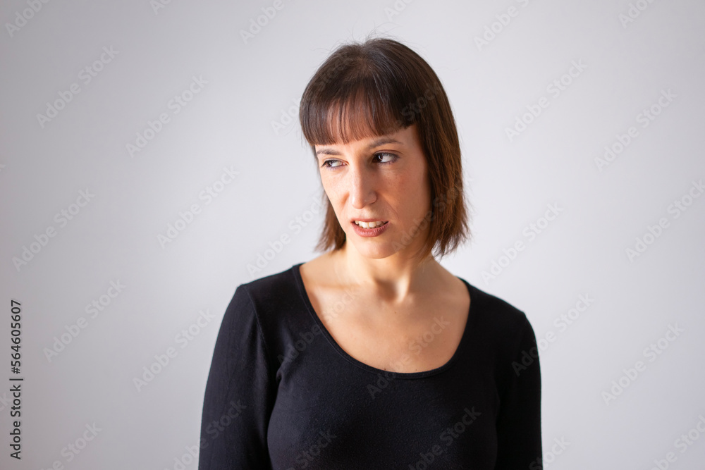 Portrait of a girl on white background. Brown short hair girl. Girl looking to the side with a disgusted face. Portrait of a girl on white background. Brown short hair girl. Girl looking to the side with a disgusted face.