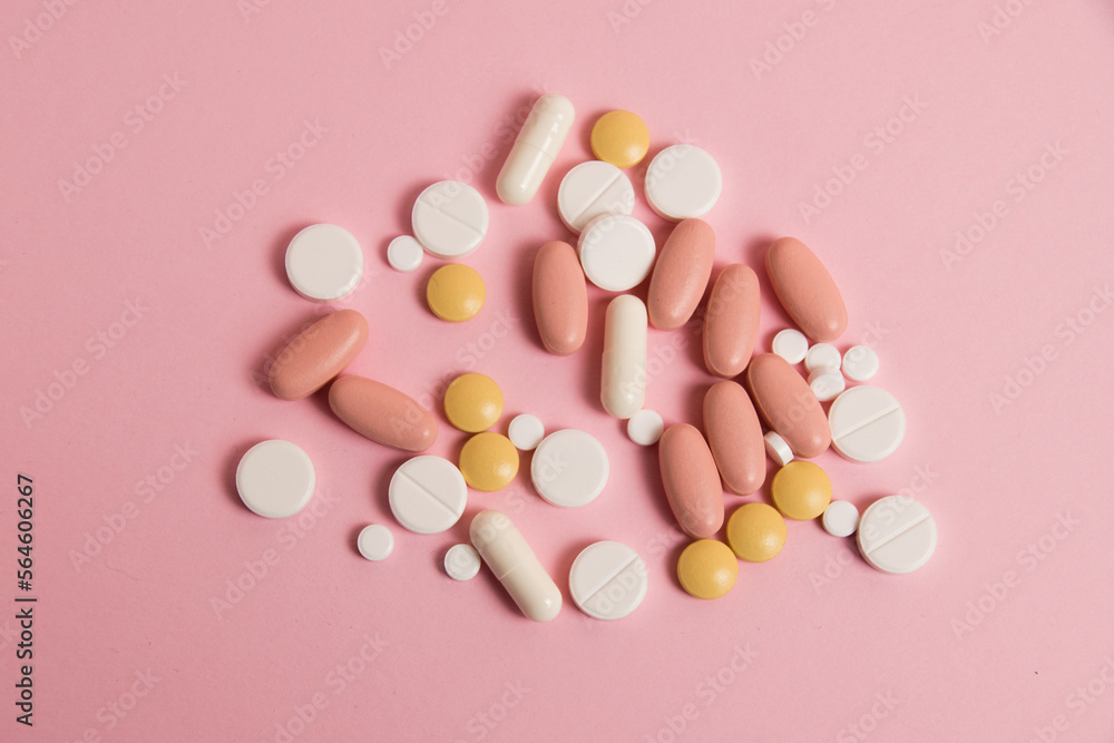 Flatlay, many different pills on a pink background Flatlay, many different pills on a pink background