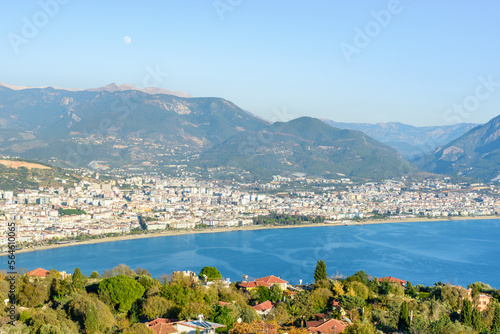 Beautiful panorama of Alanya (Turkey) with the moon on the blue sky. View from the fortress of Alanya (Alanya Kalesi)