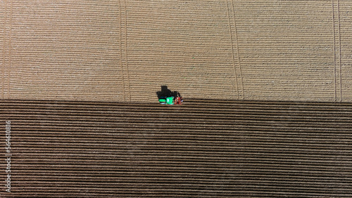 Tractor on the field from above, potato planting, aerial view.