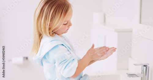 Girl washing her hands in the bathroom of her home for hygiene, stop germs and prevent bacteria. Healthcare, clean and young child doing sanitary routine with soap and water in the basin at her house