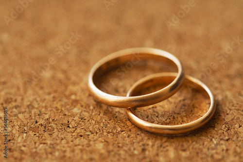 Two wedding rings on a cork table background with shallow DOF