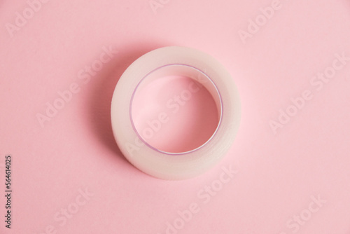 Flatlay, medical transparent plaster for applying bandages on a pink background